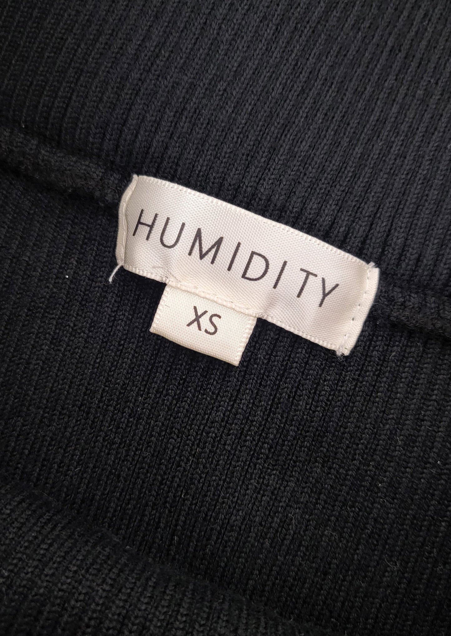 Garment size label of Black knit midi skirt, with side slit and tie at the front. 