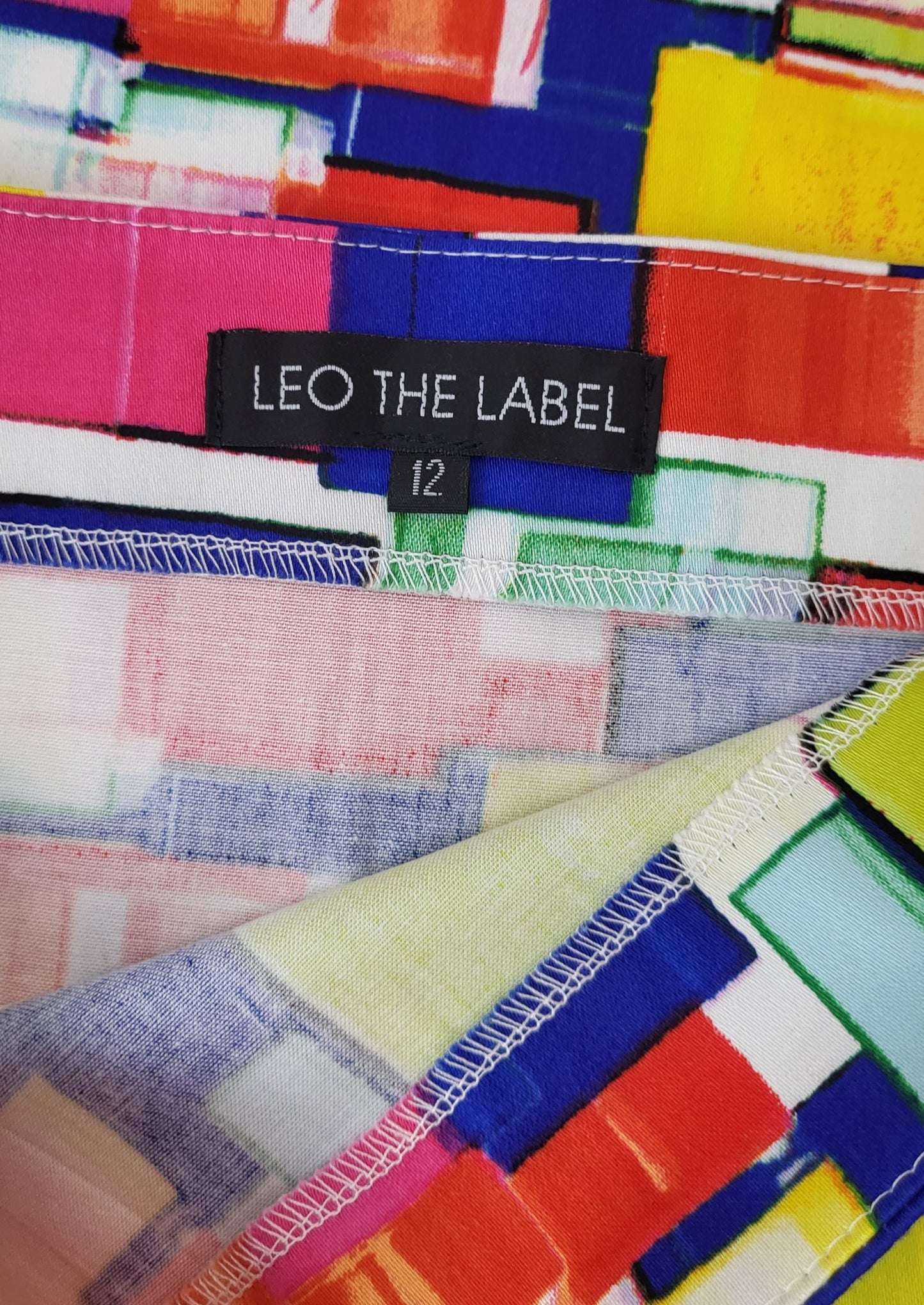 Garment size label, of Handmade by Melbourne brand Leo the Label. Bright geometric print skirt